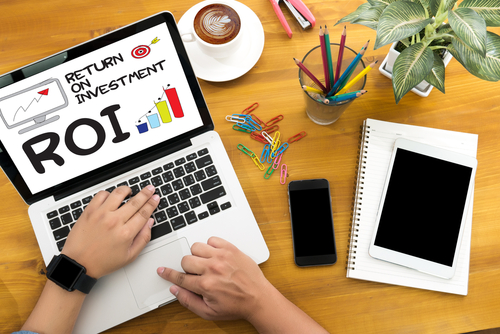 Laptop screen reading Return on Investment (ROI) on a desk