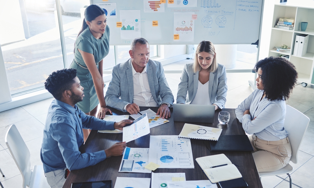 A marketing team reviewing audience research charts around a conference table